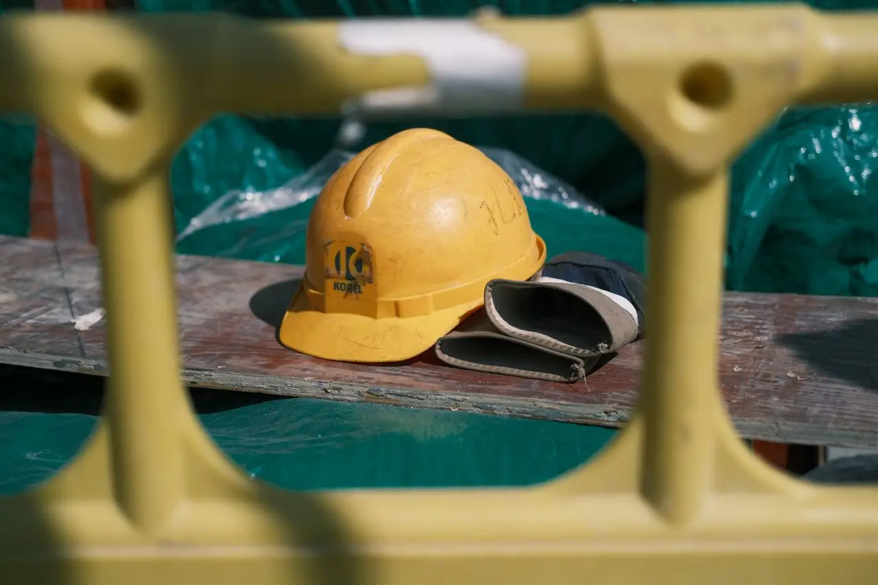 Close-up of a yellow construction helmet on a workbench at a building site.