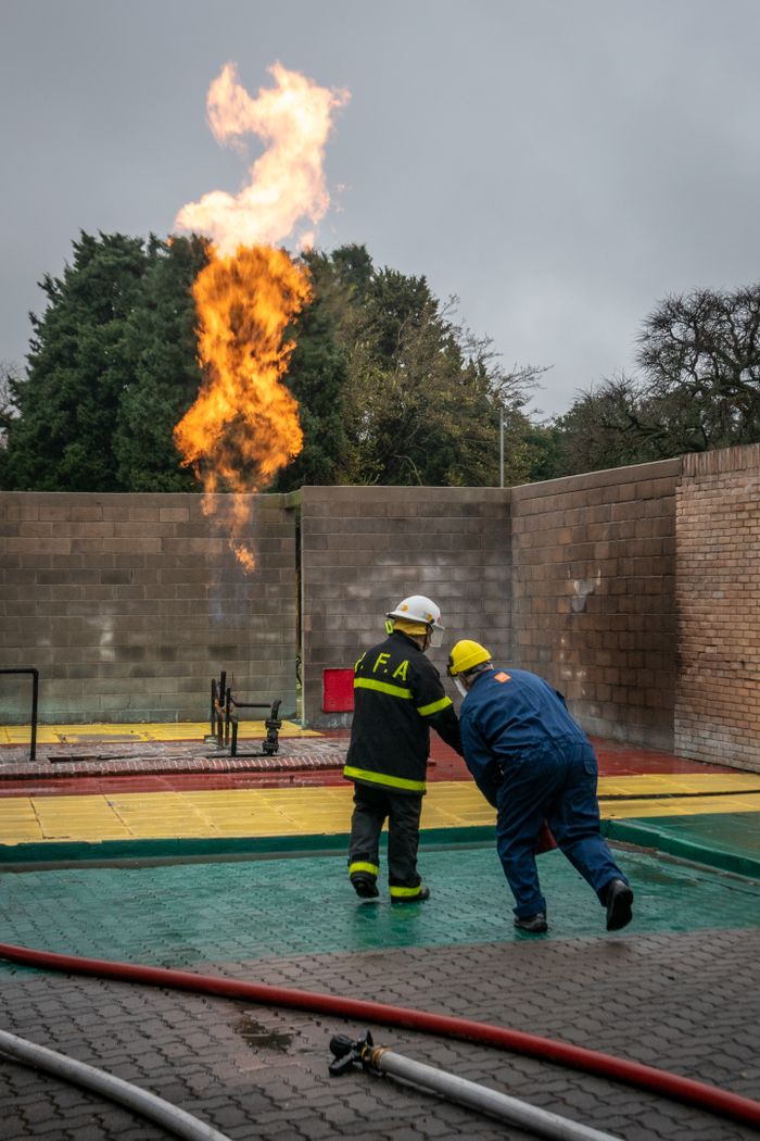 Firefighters practicing safety drills with controlled fire in Argentina.
